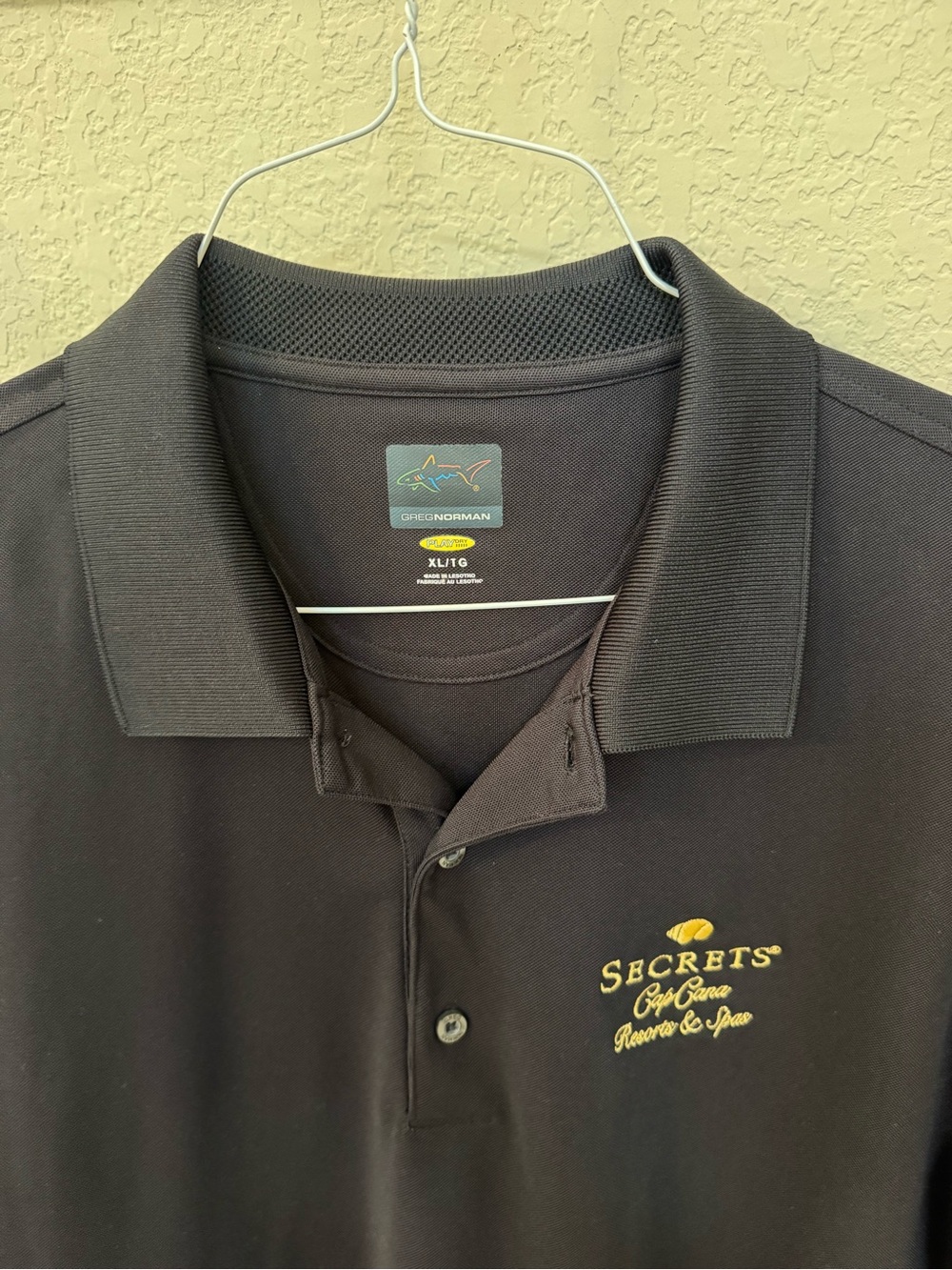 Greg Norman Collection Black Polo with Gold Secrets Cap Cana Logo. Size XL.